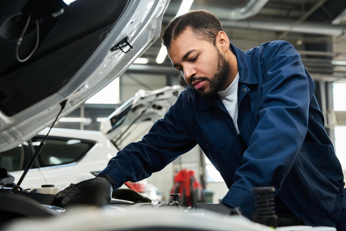 Skilled mechanic working under the hood for vehicle repair and maintenance