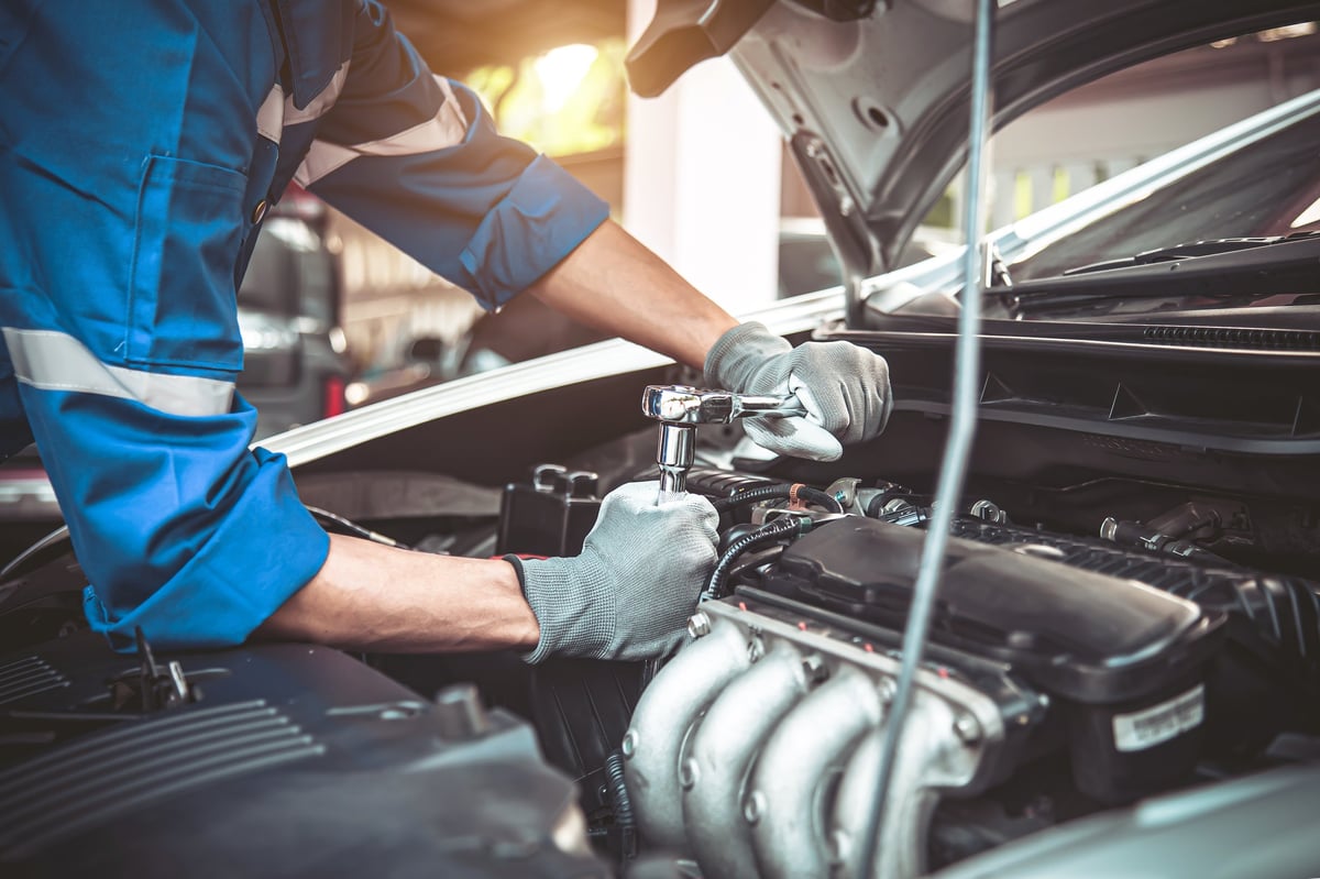 Technician using a wrench to repair a car engine